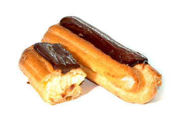 Tasty eclairs covered with chocolate on white background