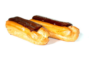 Tasty eclairs covered with chocolate on white background