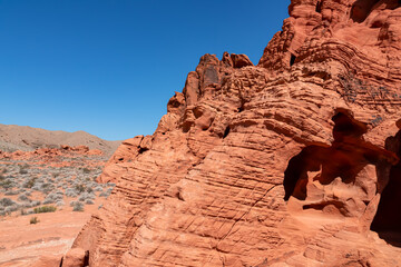 Fototapeta na wymiar Exterior view of windstone arch and fire cave in Valley of Fire State Park, Mojave desert, Nevada, USA. Scenic view of beehive shaped red sandstone rock formations. Barren deserted landscape in summer