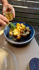 man seasoning baked potatoes with olive oil, portuguese food