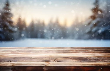 Poster Dark wooden table for product montage set against a blurry snowy landscape with silhouette trees under an orange and pink sky during sunrise or sunset, complete with falling snowflakes. © Arma Design