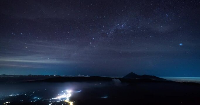 Timelapse of Milky Way rising above Mount Bromo National Park with light trails of vehicles, East Java, Indonesia