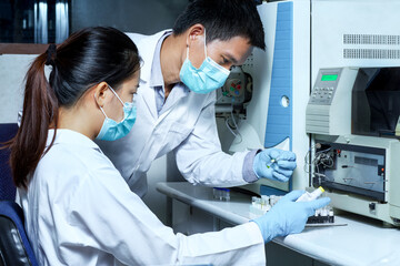 The male researcher checked the sample in the vial to analyze by Liquid Chromatography mass...
