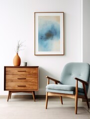 Wooden chest of cute drawers and blue chair against white wall with art poster frame. Mid century style interior design of modern living room