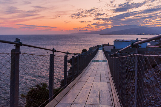 Hanging footbridge of Jolucar, with the Mediterranean Sea in the background at sunset, Granada coast.