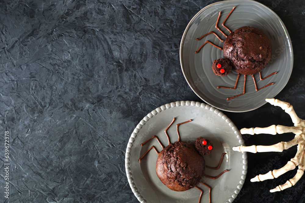 Poster spooky halloween spider muffins. above view over a dark slate background with copy space.