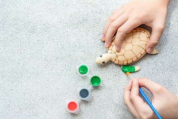 Kid's hands with turtle toy