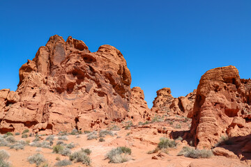Scenic view of red rock sandstone formation in the Valley of Fire State Park, Nevada, USA. Aztec Sandstone, which formed from shifting sand dunes. Road trip in summer on a hot sunny day with blue sky