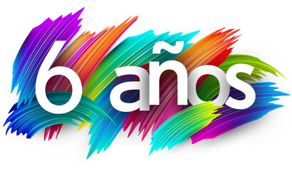 6 years at spanish paper word sign with colorful spectrum paint brush strokes over white. Vector illustration.