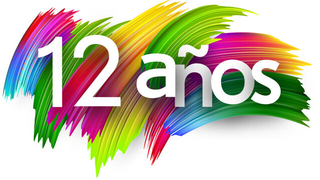 12 years at spanish paper word sign with colorful spectrum paint brush strokes over white. Vector illustration.