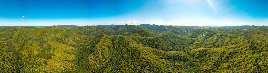 Fototapeta na wymiar mountains of the Western Caucasus, light clouds and a blue stripe of the sea on the horizon a large panorama - a view on an almost cloudless summer day