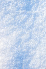 Snowy background, snowy surface with a clearly expressed texture of snow in the morning sun