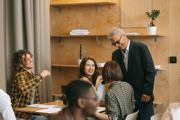 Fototapeta premium Senior business owner greeting his young talented junior employees. They are about to work in a good atmosphere