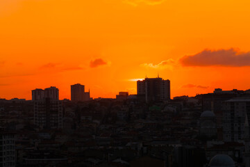 Fototapeta na wymiar Colorful orange sunset sky over the city of Istanbul, Turkey in the evening - apartment, residential buildings silhouettes. Summer, architecture, cityscape and urban concept