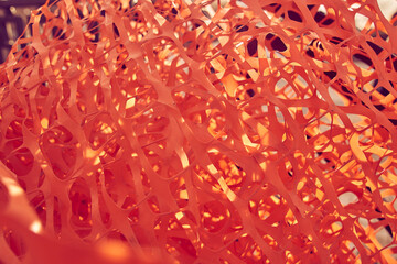 Selective focus on building supplies a bunch of orange mesh for reinforcing walls in the process of warming a building outdoors. High quality photo