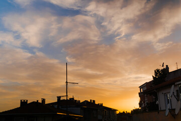 View of dramatic sunset sky with clouds over the city of Istanbul, Turkey in the evening - view of rooftops of buildings in Uskudar district. Urban and cityscape concept