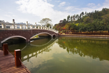 Fototapeta na wymiar The big pool and the bridge near to hotel in the Chinese city