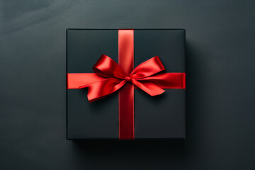 Black box with red ribbon on it and bow.
