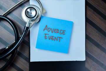 Concept of Adverse Event write on sticky notes with stethoscope isolated on Wooden Table.