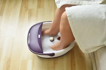 Fototapeten Electric, massage foot bath.  Relaxation for tired feet and pedicure at home. © Natalia