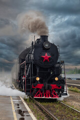 Fototapeta premium An old steam locomotive of the early 20th century on the railway track.