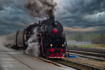 An old steam locomotive of the early 20th century on the railway track.