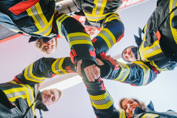 Fire fighter men and women doing some teambuilding stacking hands - 639692980