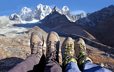 Two travelers relax while trekking in Nepal and admire the mountains - 639695330