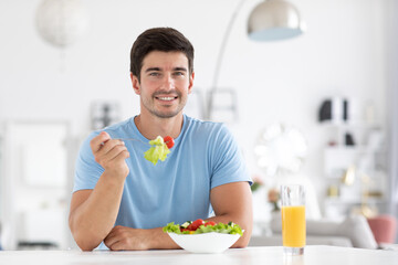 Healthy eating in office, man has lunch with fresh salad