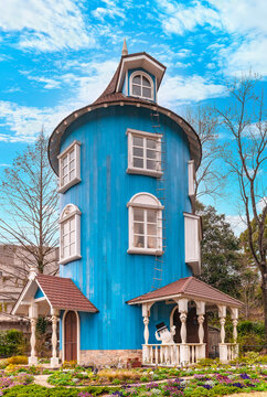 japan, saitama - march 26 2023: The blue wooden Moomin house called Muumitalo with the cute Moominpappa wearing his black top hat and cheerfully waving with his hand in the Japanese Moominvalley park.