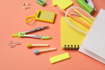 Composition with paper bag and various stationery on color background