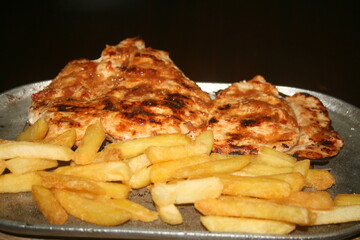 roasted chicken fillet with French fries on dark background ready for your projects