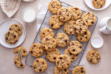 Chocolate chip cookies on a cooling rack with flaky salt served with milk
