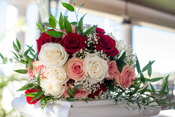 Gorgeous back lit bridal bouquet of red, pink and whit roses