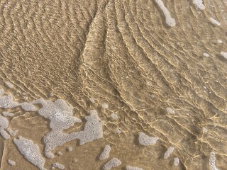 a foamy wave on the sand of the north sea beach