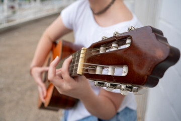 Crop female guitarist performing song on guitar