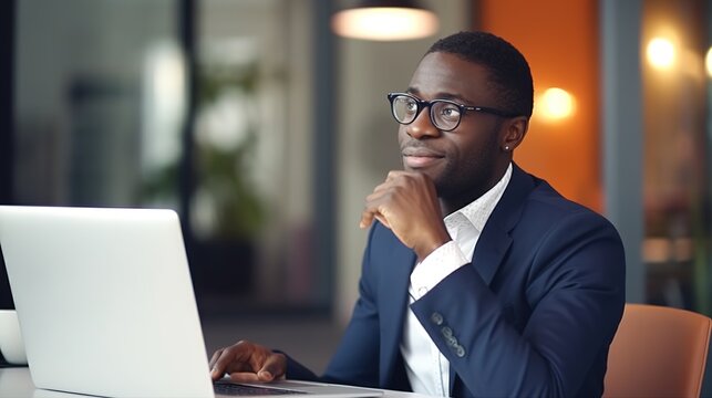 image of an African-American businessman working on a laptop computer at his desk. 