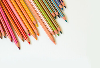 Colorful striped dry crayons on white surface with copy space.Above view