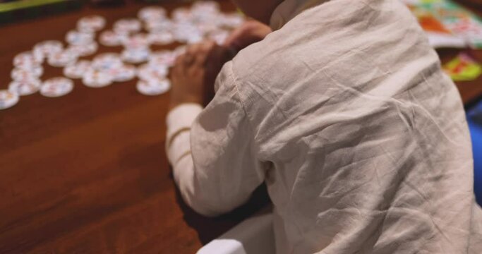 Process of playing board game and having fun with friends and family in room indoors, board game concept, group of kids children play board games at the table, roll the dice 