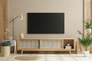 TV on the wood cabinet in modern living room with plant on cream color wall background.