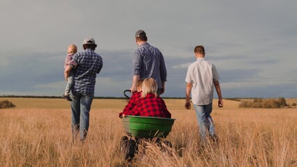 Happy farmer family with different age children play in country field together