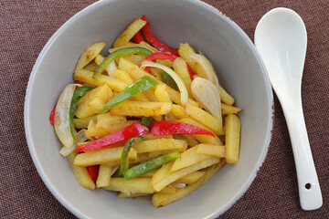 Korean Stir-fry potatoes or Gamja Bokkeum on marble background. Korean Chili pepper and potato Stir-fried in bowl. Korean vegetable side dish