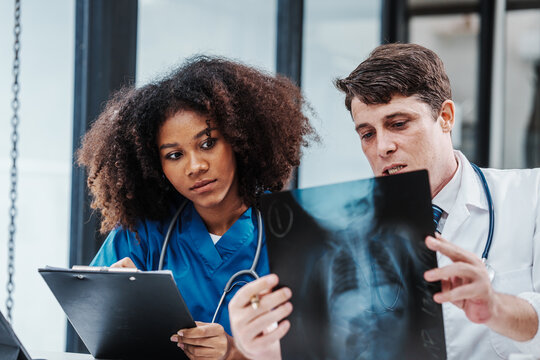 Medical staff team african american meeting discussing chest x-ray film Radiologists medical doctors that specialize in diagnosing, treating injuries, diseases, radiology, procedures exams, tests