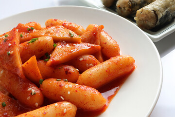 Korean food, Rice cake stick in a spicy gochujang sauce and fish cakes. Tteokbokki and Fried seaweed rolls or Gimmari on white background. Korean Stir-fried Rice Cake