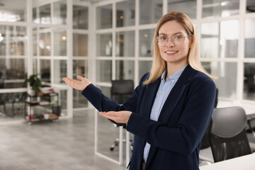 Happy female real estate agent in office