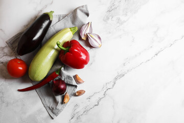 Fresh vegetables for ratatouille on white marble table, flat lay. Space for text