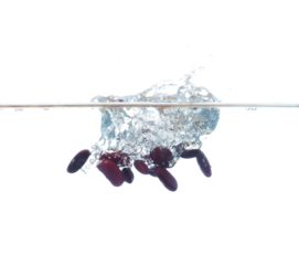 Red liver Beans falls into water and creates air bubbles on surface. Red beans drop hit smash to boil water and deep to bubble. White background isolated freeze motion