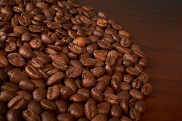 Fototapeta premium Aromatic Elegance: A close-up masterpiece capturing the intricate details of coffee beans on a rich wooden texture. The interplay of texture and aroma unfolds against a warm backdrop