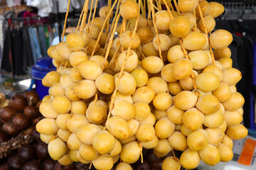 Close-up of Fresh raw yellow date palm or dates at a market.