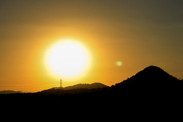 A beautiful sunrise behind behind the shadow of mountains. Shadow of black mountains and trees at sunrise. enjoy the relaxing nature concept.